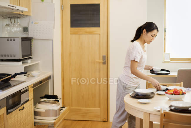 Femme préparant un repas dans une cuisine — Photo de stock