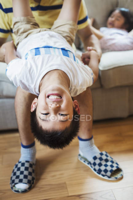 Man holding son upside down — Stock Photo
