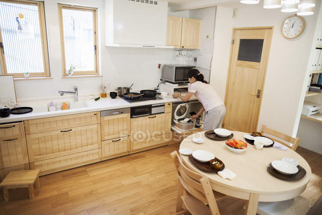 Mulher preparando uma refeição em uma cozinha . — Fotografia de Stock