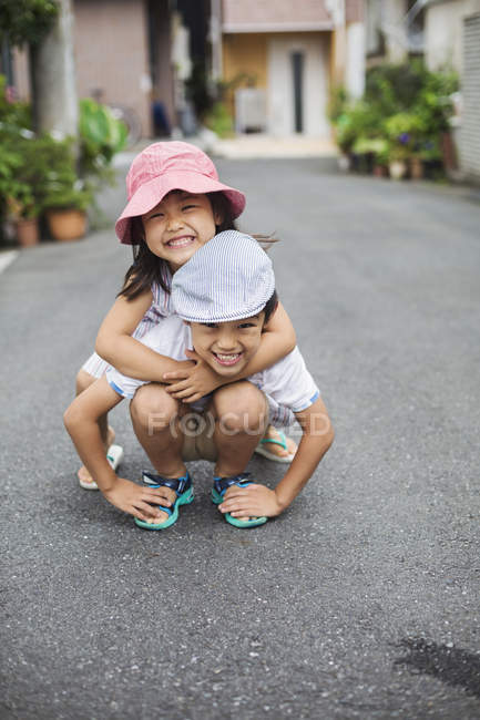 Niño y niña jugando al aire libre. - foto de stock