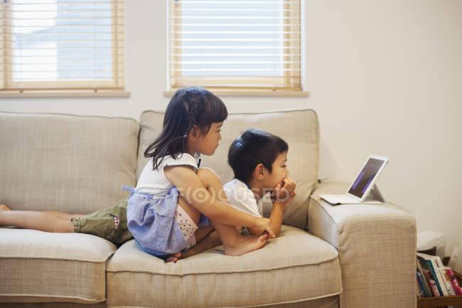 Мальчик и девочка смотрят цифровой планшет . — стоковое фото