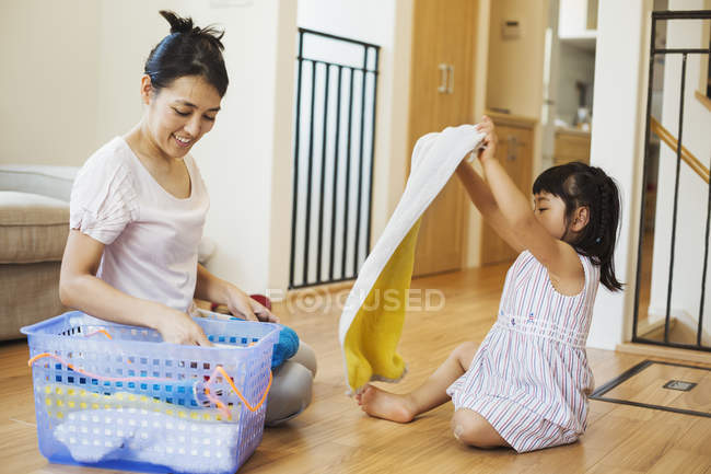 Donna e figlia pieghevole lavanderia pulita
. — Foto stock