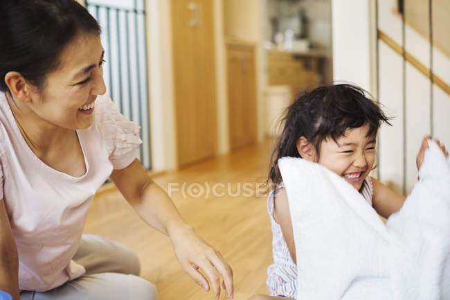 Mulher e filha dobrar a roupa limpa . — Fotografia de Stock