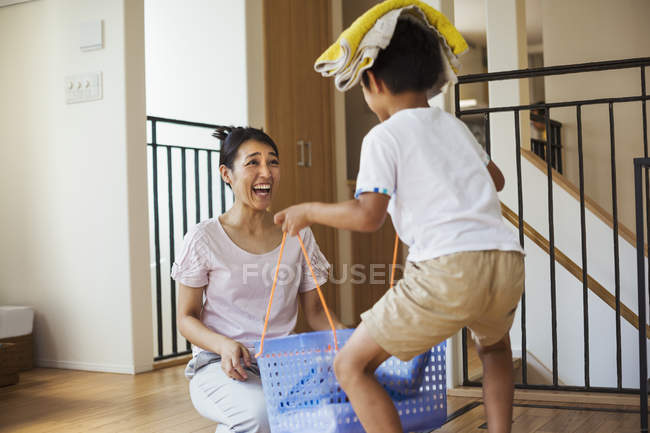 Женщина и сын сортируют белье — стоковое фото