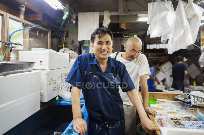 Personas que trabajan en el mercado tradicional del pescado - foto de stock