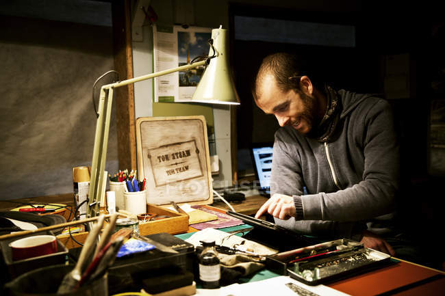 Mann in seiner Werkstatt mit digitalem Tablet — Stockfoto