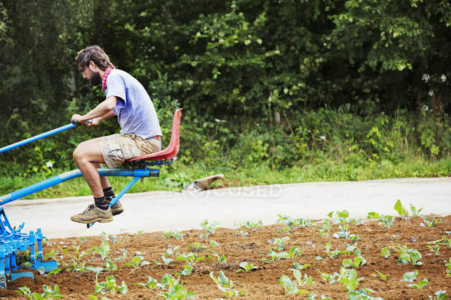 Homem sentado em um cultivador — Fotografia de Stock