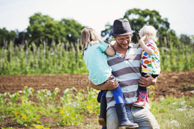 Man carrying two children — Stock Photo