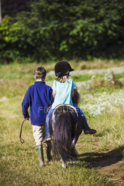 Ragazza cavalcando un pony — Foto stock