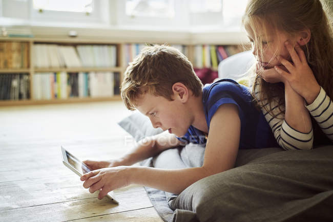 Двоє дітей, які діляться цифровим планшетом — стокове фото
