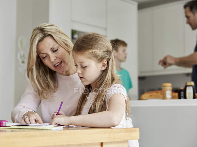 Frau und ihre Tochter sitzen an einem Tisch — Stockfoto