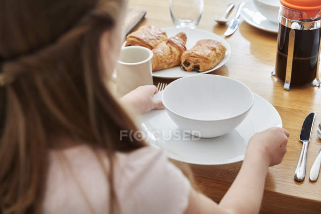 Chica poniendo la mesa para el desayuno - foto de stock
