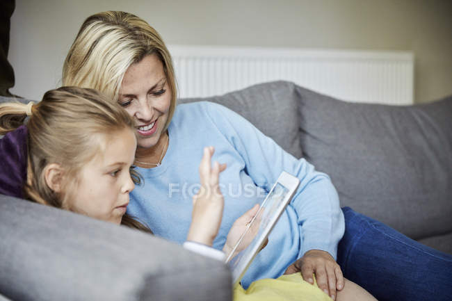 Mãe e filha usando um tablet digital . — Fotografia de Stock
