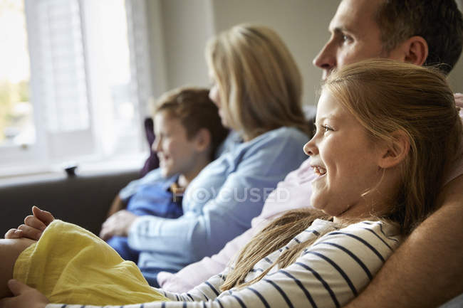 Familia en casa sentada en un sofá juntos . - foto de stock