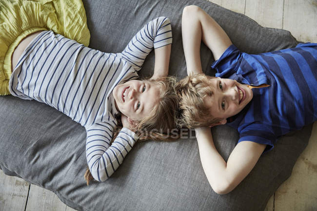 Мальчик и девочка лежат на диване — стоковое фото