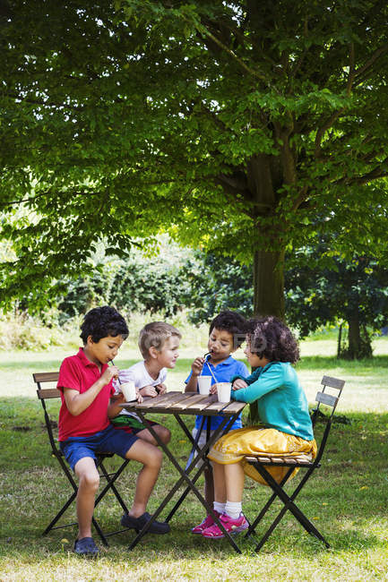 Kinder sitzen an einem Tisch — Stockfoto