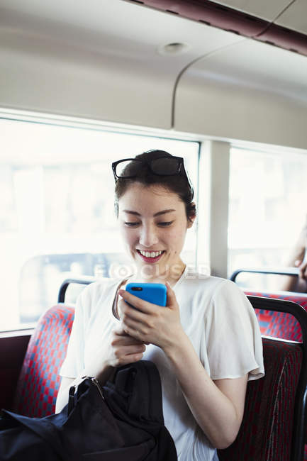 Japonesa mujer cabalgando en autobús . - foto de stock