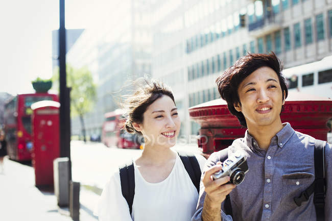 Japanese man and woman walking down a street. — Stock Photo
