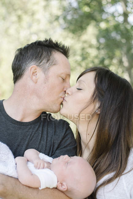 Parents holding a small baby — Stock Photo