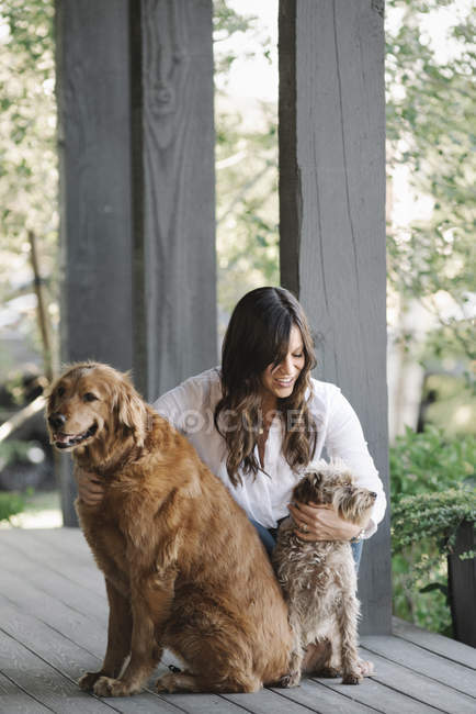 Жінка обіймається з собаками — стокове фото