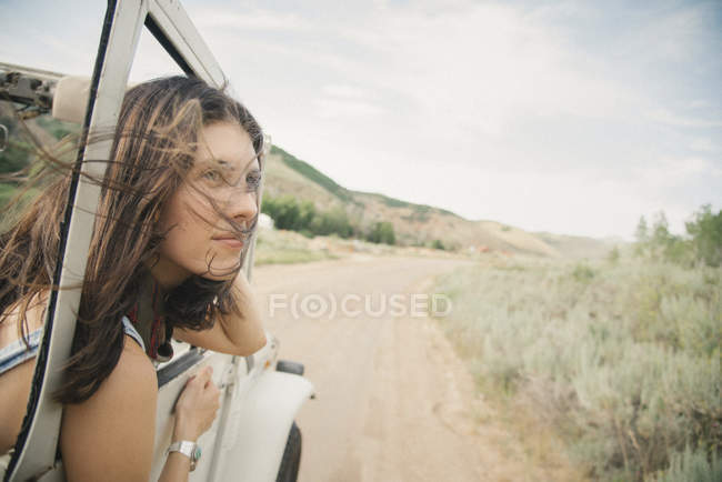 Femme penchée hors de jeep en mouvement — Photo de stock