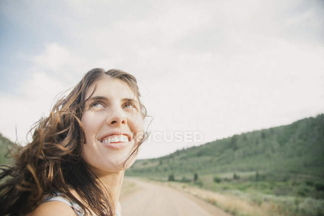 Jeune femme avec des cheveux soufflés par le vent — Photo de stock