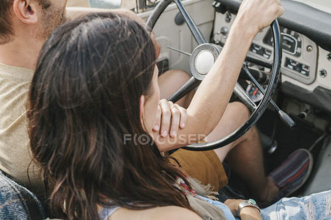 Couple assis dans une jeep à toit ouvert . — Photo de stock