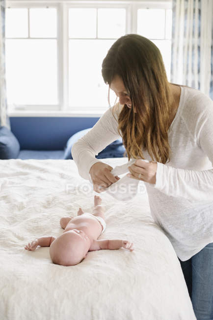 Mãe vestir seu bebê jovem — Fotografia de Stock