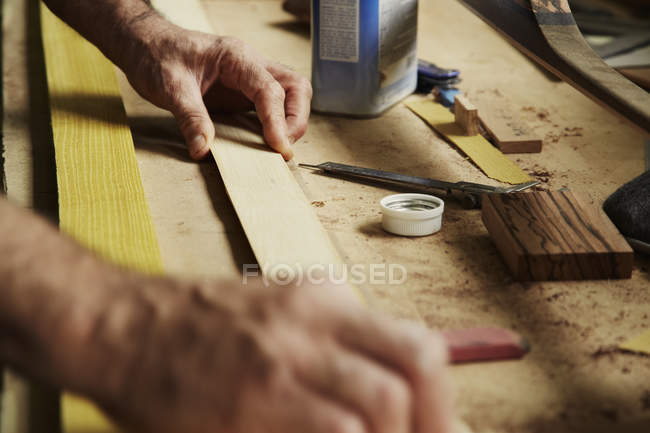 Carpinteiro segurando pedaço de madeira — Fotografia de Stock