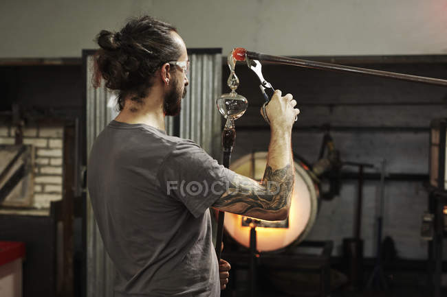 Souffleur de verre travaillant sur un morceau de verre — Photo de stock