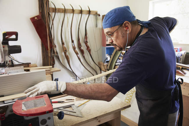 Man working on wooden bow — Stock Photo