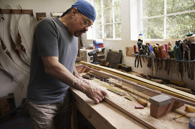 Hombre trabajando en arco de madera - foto de stock