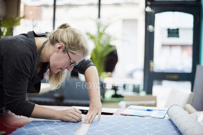 Woman measuring and marking fabric — Stock Photo