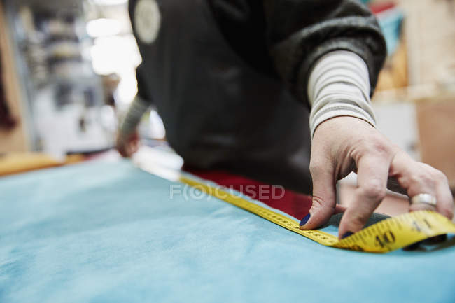 Mujer que mide la tela de tapicería - foto de stock