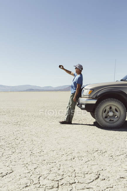 Человек, использующий смартфон в пустыне — стоковое фото