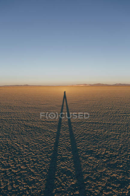 Отбрасывая длинную тень человека — стоковое фото
