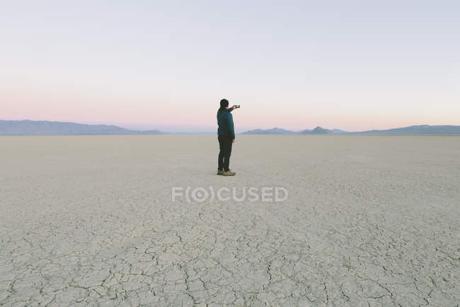 Uomo in piedi nel vasto deserto playa — Foto stock