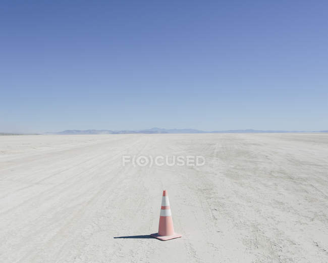 Cono de tráfico en el vasto desierto - foto de stock