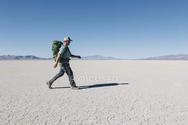 Чоловічий рюкзак пішохідний у величезній пустелі — стокове фото