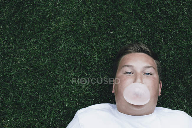 Хлопчик дме бульбашкова жувальна гумка — стокове фото