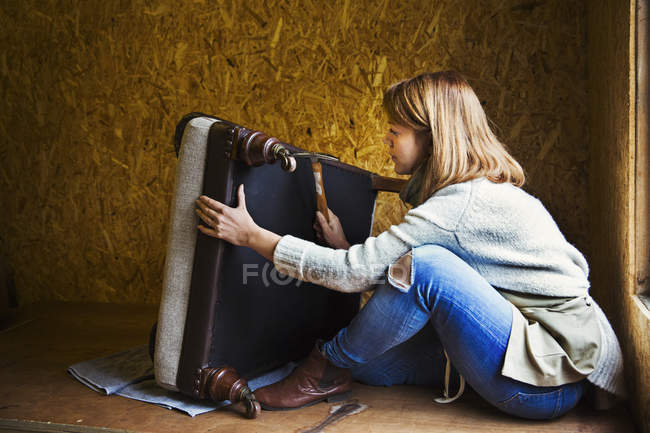 Женщина работает и ремонтирует кресло — стоковое фото