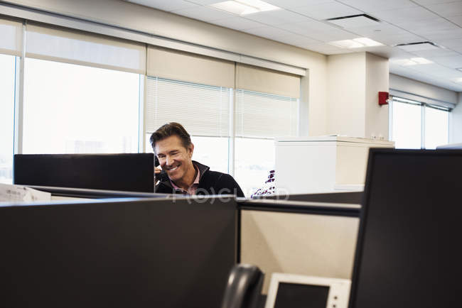 Man sitting in office cubicle — Stock Photo