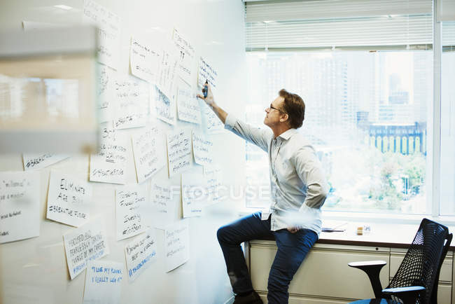Mann stützt sich auf Schreibtisch im Büro — Stockfoto