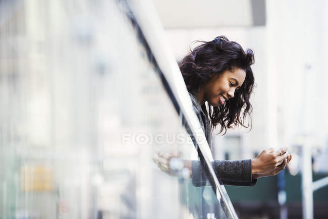 Woman leaning over balcony rail — Stock Photo