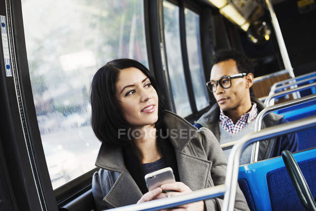 Mujer y hombre sentados en el transporte público - foto de stock