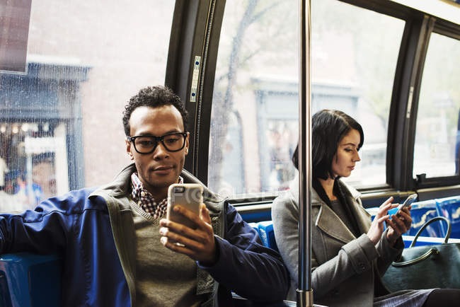 Mujer y hombre sentados en el transporte público - foto de stock