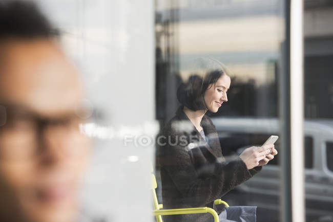Женщина смотрит на мобильный телефон — стоковое фото