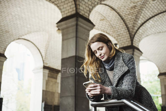 Frau sucht Smartphone — Stockfoto