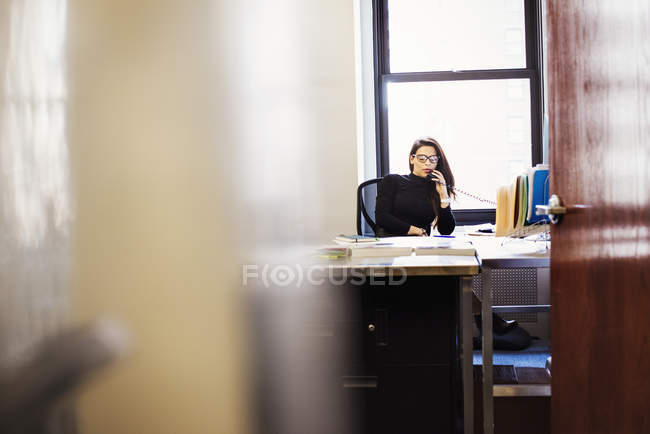 Mulher sentada na mesa no escritório — Fotografia de Stock