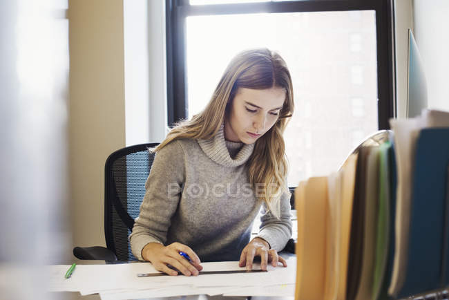 Mulher sentada na mesa no escritório — Fotografia de Stock